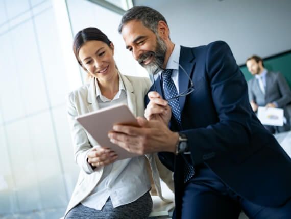 two business associates looking at a tablet device