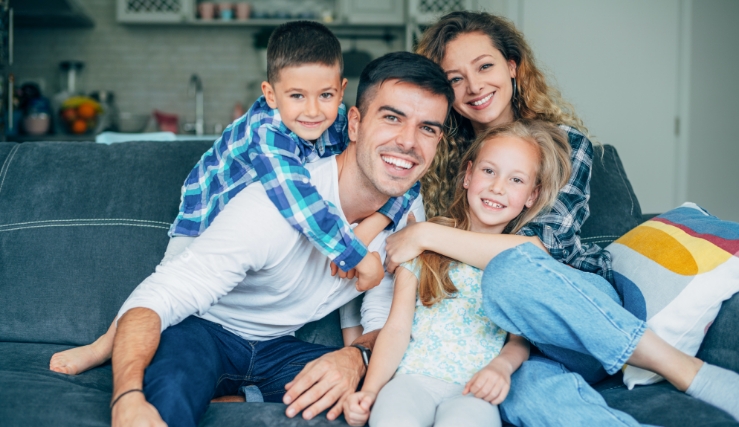 a family of four together on a couch